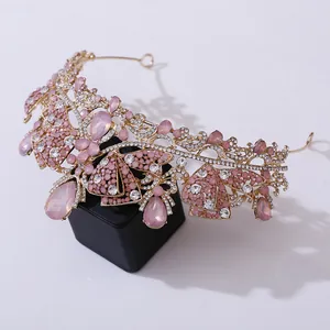 Elegant gold bridal tiara with pink crystals and butterfly accents for weddings