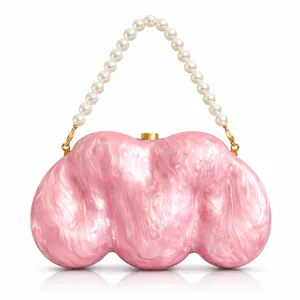 Detail view of pink acrylic shell evening bag with luxury white pearl handle and gold clips
