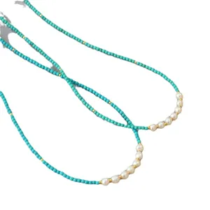 Collier bohème en perles turquoise avec perles d'eau douce et accents dorés sur blanc
