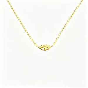 Detail of gold evil eye pendant with eyelash texture on a fine cross chain necklace