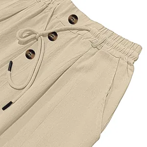 Detailed close-up of cotton linen trousers featuring elastic waist with drawstring and buttons
