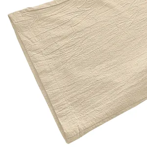 Detail shot of breathable cream linen fabric texture and neat stitching on casual pants