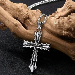 Collier pendentif croix gothique argentée avec bords épineux sur décor en bois