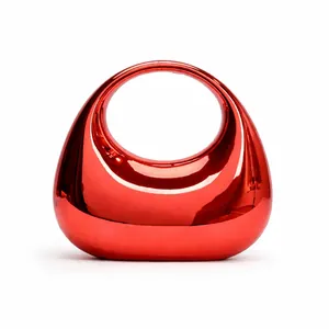 Close-up of metallic red acrylic handbag with glossy mirror finish and minimalist design