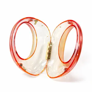 Top view of open acrylic handbag with orange gradient finish and gold metal hinges