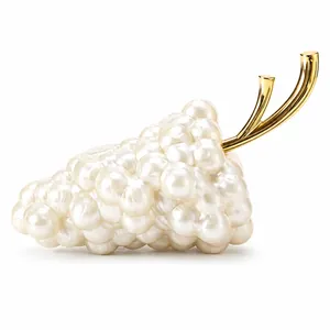 Grape-shaped clutch bag made of faux pearls with golden metallic handles on white background