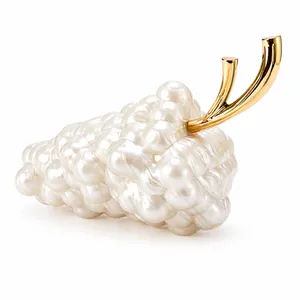 Macro view of pearl beaded grape-shaped evening bag with a golden metal handle