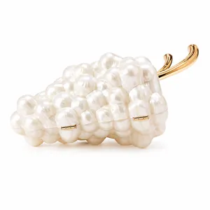 Macro detail of grape-shaped clutch bag with iridescent pearls and gold metal hardware