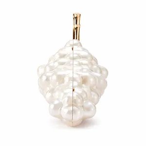 Detailed close-up of pearl white grape-shaped evening clutch with gold metal handle
