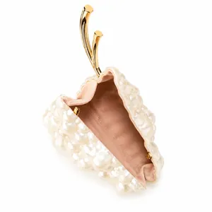 Detailed interior of pearl evening clutch bag with elegant golden curved metal handle