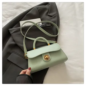 Detailed close-up of mint green leather handbag with vintage golden circular buckle