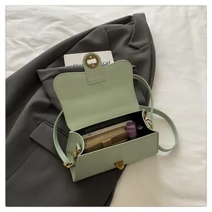 Detail view of the pale green shoulder bag interior showing capacity for phone and wallet