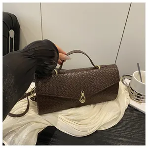 Vue détaillée de la texture tressée et de la boucle infinie dorée du sac à main