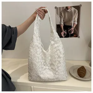 Detail of white lace tote bag with floral embroidery held by a model in a French retro style