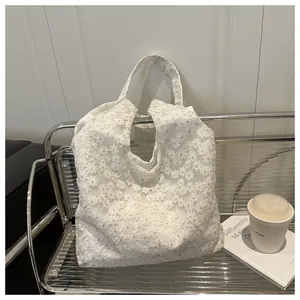 Detailed close-up of white mesh lace daisy embroidery on a stylish summer tote bag