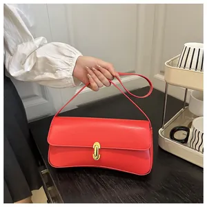Detailed view of the red smooth leather shoulder bag with a gold oval metal clasp closure