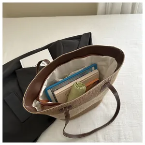 Spacious interior of woven straw tote bag showing books and umbrella with lining