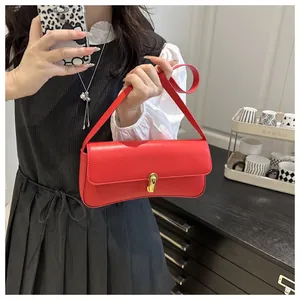 Detail of red square shoulder bag with golden metallic clasp on model in vintage dress