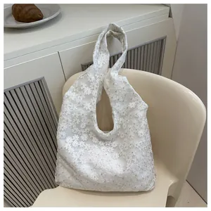 Detail of white daisy lace tote bag with semi-transparent floral mesh texture