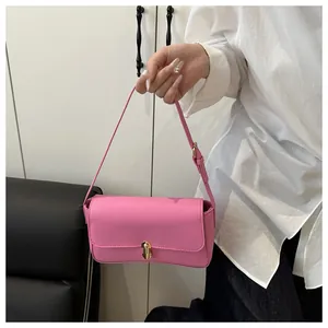 Close-up of pink faux leather bag featuring a gold metal lock and fine stitching