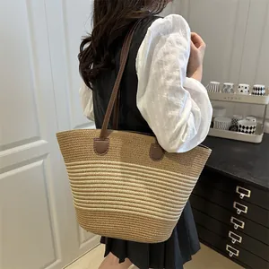 Women's woven straw tote bag with striped texture and brown leather straps