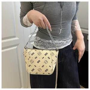 Détail d'un sac seau beige en cuir grainé avec motif d'ours et chaîne en argent