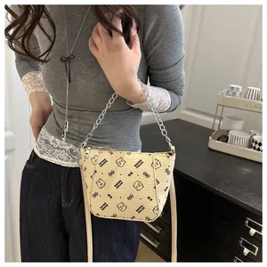 Détail du sac seau crème avec imprimé ours, poignée chaîne argent et bandoulière