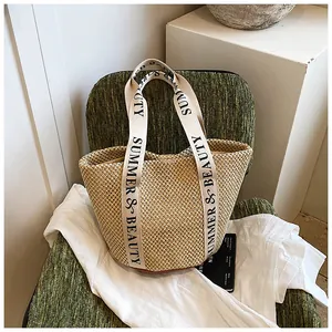 Gros plan du sac seau en paille avec des anses en toile SUMMER & BEAUTY