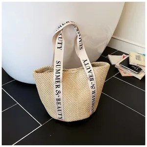 Détail du sac fourre-tout en paille tissée avec texte noir SUMMER & BEAUTY et anses