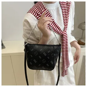 Détail du sac seau noir texturé avec chaîne argentée et motifs d'ours imprimés