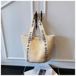 Détail du sac seau en paille tissée avec anses en toile imprimées Summer & Beauty