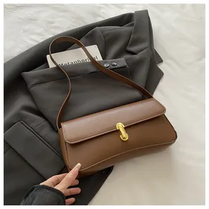 Detailed view of caramel square shoulder bag with gold metal U-shaped buckle closure