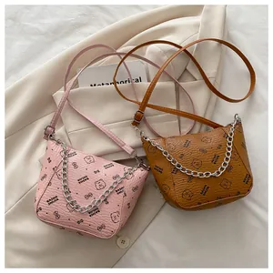 Détail de sacs à main avec chaîne, imprimé ours et cuir texturé en rose et marron