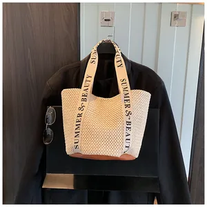 Détail d'un sac cabas tissé avec anses en ruban 'SUMMER & BEAUTY' et base en cuir élégante