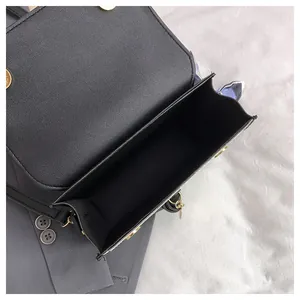 Detail view of the spacious inner compartment and lychee texture of the black square bag