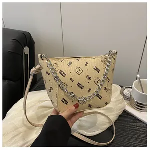 Détail du sac seau beige avec texture litchi et motifs imprimés d'ours de dessin animé
