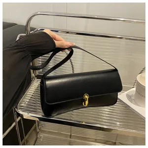 Close-up of elegant black leather handbag with a sleek gold metal lock and texture