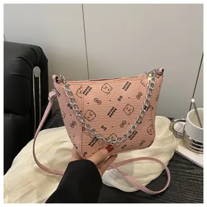Détail du sac seau rose en similicuir avec imprimé ours et bandoulière en chaîne