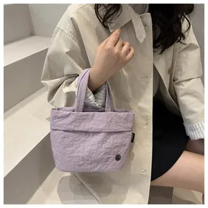 Close-up of purple bucket bag with unique bubble textured fabric and metal logo detail
