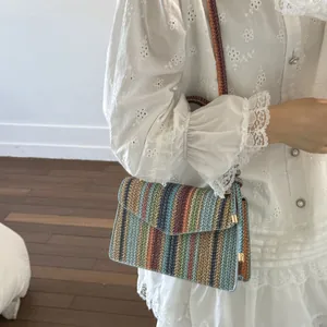 Detail of colorful woven shoulder bag with vibrant stripes and gold metal hardware