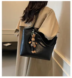 Gros plan du sac cabas rétro noir avec un pendentif lapin mignon et texture cuir PU