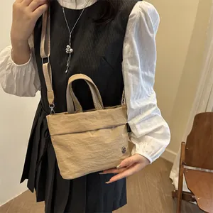Minimalist beige bucket bag with top handle and shoulder strap for daily commuting