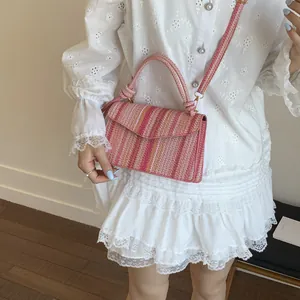 Detailed texture of colorful bohemian woven straw handbag with striped pattern