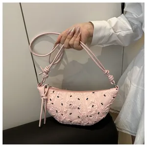 Detailed embroidery of black rabbits on pink faux leather shoulder bag with knotted strap