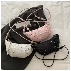Detail of croissant bags with pleated texture, bow patterns, and knotted straps