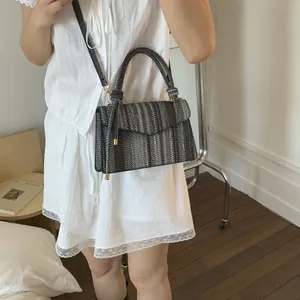 Detail of gray woven crossbody handbag with envelope flap and chic braided top handle