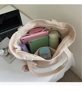 Top view of spacious canvas tote interior holding a laptop and daily essentials