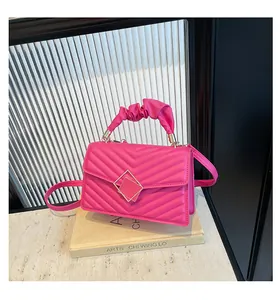 Macro detail of fuchsia quilted mini bag with scrunchie handle and gold square buckle