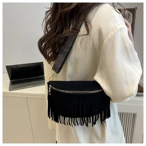 Detail of black suede waist bag featuring long fringes and ethnic woven shoulder strap