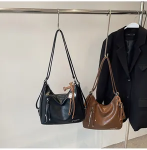 Détail du sac hobo uni avec fermetures éclair latérales et texture en cuir souple